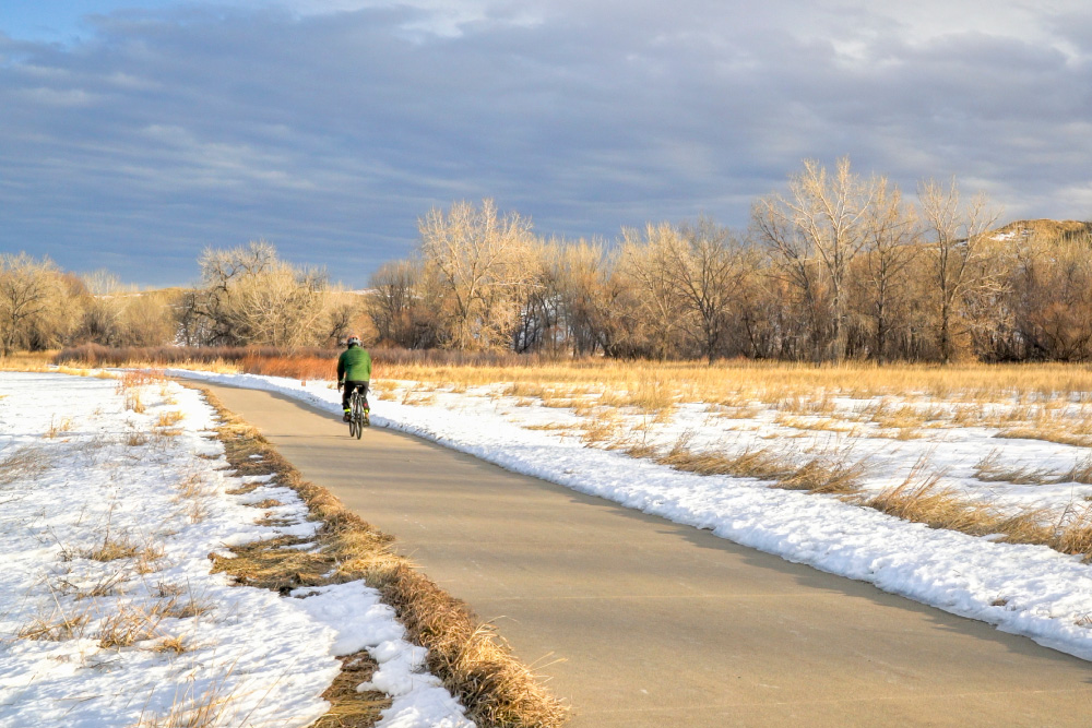 Cyclist on road with snowy landscape